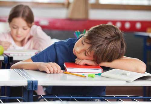 به خواب رفتن دانش آموز بر روی نیمکت خود